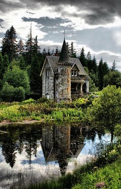 an old castle like building in the middle of a forest with trees and bushes around it