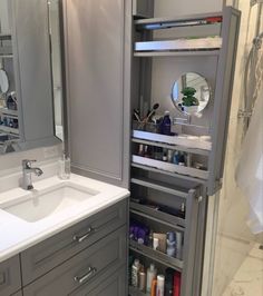 a bathroom with gray cabinets and white counter tops