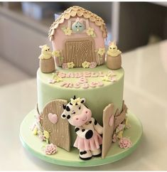 there is a cake decorated with a cow and farm animals on it's side