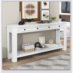 a white console table with two drawers and pictures on the wall in front of it