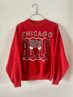 "Vintage 1990's Chicago Bulls Heavyweight Sweatshirt Pullover style, bright red, super cozy. In mint condition, possibly never worn. Graphic super vibrant, no stains or holes.  Officially Licensed product of the NBA - Team Hanes production. Tag size Men's XL maybe more like a modern day Large. See measurements to be sure of fit.  Measurements lying flat: pit to pit: 24\" shoulders: 22.5\" sleeve: 22.5\", length: 25\"" Red Graphic Sweatshirt For Sports Events, University Red Crew Neck Sweatshirt For Sports Season, Red Graphic Print Sweatshirt For Sports Events, Red Crew Neck Sweatshirt For Fans, Red Sweatshirt For Sports Season Fan Merchandise, Red Sweatshirt For Sports Fan Merchandise, Red Crew Neck Sweatshirt For Fan Merchandise, Red Crew Neck Sweatshirt For Sports Events, Red Oversized 90s Tops