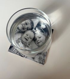 a glass with some pictures in it sitting on top of a table