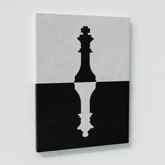 a black and white photo with a chess piece on it's side, against a wall