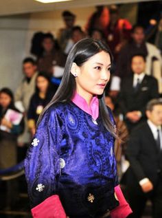 a woman in a blue and pink dress is walking down the runway with other people behind her