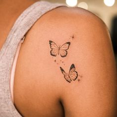 two butterflies on the back of a woman's shoulder