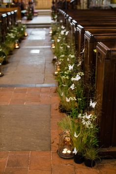 rows of pews decorated with flowers and candles