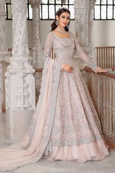 This luxurious long gown features a double beaded neckline and intricate hand detailing with pearls, diamonites, sequins, and 3D floral work. It has a scalloped worked border cascading over a tulle-based lehenga. The dupatta's head border is hand embellished, while the other three sides have an embroidered border with pearl-finished scalloped edges. Style: Long Gown with Lehnga Disclaimer: "Look of the dress may vary as per customer's height." Color: Pale Pink (Gown, Dupatta, Lehnga, Blouse) Fab Tissue Lengha, Organza Long Gown, Asian Wedding Outfits, Pastel Pink Dress