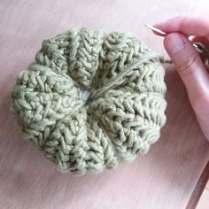 a crocheted object being worked on by someone's hand while they are knitting