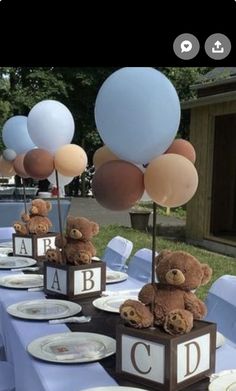 a table topped with lots of balloons and teddy bears sitting on top of each other