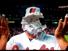 a baseball player wearing a paper mask and holding up his hands in front of him