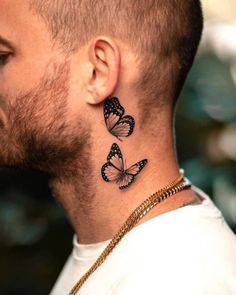 a man's neck with two butterflies on it