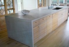 a modern kitchen with stainless steel counter tops and wooden cabinets in an open floor plan