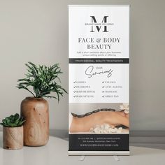 a white sign sitting on top of a table next to a potted plant and wooden vase