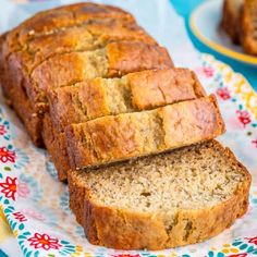 a loaf of banana bread sitting on top of a paper plate next to another loaf