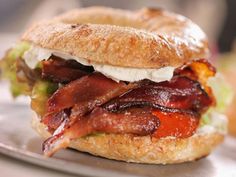 a bacon, lettuce and tomato sandwich on a bagel bun with sour cream