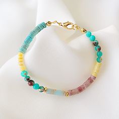 This natural stone bracelet is made with 4mm rectangular cut blue variscite, rhodonite stones, rondelle shape turquoise variscite beads, rondelle shape yellow agate beads and natural mother of pearl beads. The finish of the bracelet is gold plated. ✔️ Variscite is a stone of hope and encouragement. It is a wonderful stone for clearing up emotional confusion and seeing straight to the heart. It fuels up the heart chakra and bring the unconditional love in the life.  ✔️ Agate is an excellent stone for rebalancing and harmonising body, mind and spirit.  It cleanses and stabilises the aura, eliminating and transforming negativity.   ✔️ Rhodonite grounds energy, balances yin-yang, and aids in achieving one's highest potential. It stimulates, clears and activates the heart.   Packaged in a glitt Multicolor Gemstone Rondelle Bracelets, Multicolor Spiritual Bracelets With Natural Stones, Pietersite Bracelet, Multicolor Hand-strung Agate Crystal Bracelet, Bracelet Heishi Pierre Naturelle, Glitter Gifts, Natural Stone Bracelets, Dainty Bracelets, Agate Beads