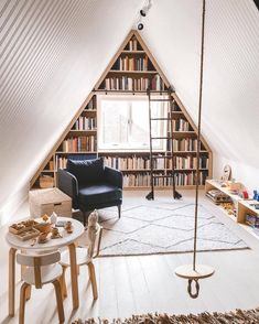 a room with a chair, table and bookshelf in it