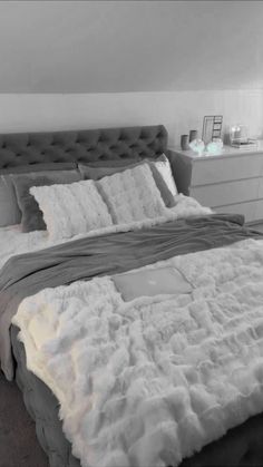 a bed with white and grey sheets in a room