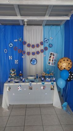 a blue and white dessert table with balloons