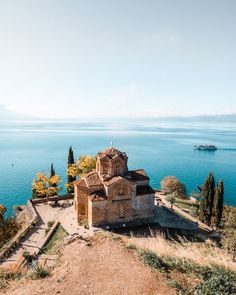 an old church sitting on top of a hill next to the ocean