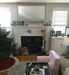 a living room filled with furniture and a christmas tree on top of a coffee table