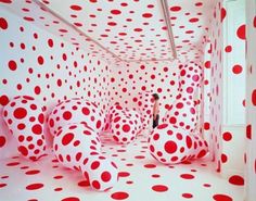 a woman is standing in the middle of a room with red and white polka dots