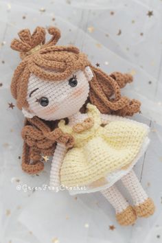 a crocheted doll is sitting on the floor with her hand in her pocket