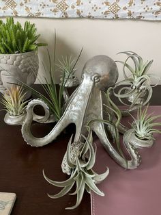 an octopus planter is sitting on a table next to other air plants and succulents