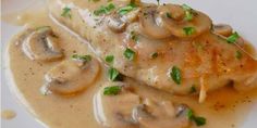 a white plate topped with meat covered in mushroom gravy