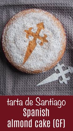 a close up of a cake with powdered sugar on it and the words tarta de santiago spanish almond cake gf