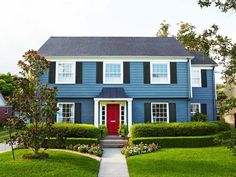 a blue house with black shutters and red door