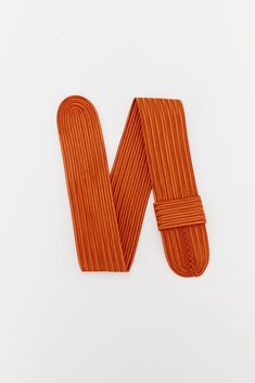 the letter m made out of orange cord on a white background with clippings