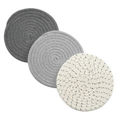 three round rugs with white and grey designs on the bottom, one is circular