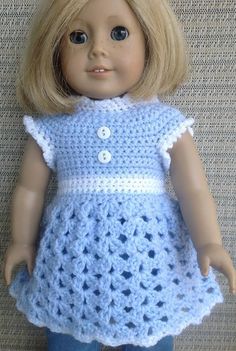 a doll with blonde hair wearing a blue crocheted dress and jeans on a couch