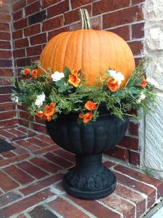 a large pumpkin sitting on top of a black planter