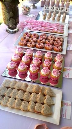 a table topped with lots of cupcakes and cookies