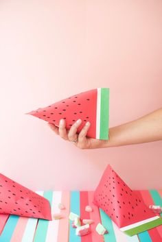 watermelon paper boats and marshmallows are arranged on a striped tablecloth