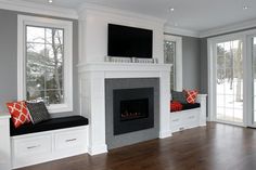 an empty living room with two couches and a television on the fireplace mantel