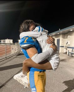 a football player is holding his son in the air