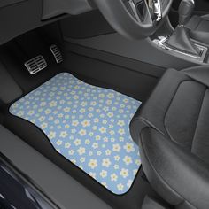 the interior of a car with a blue and white flowered floor mat on it