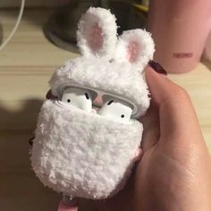 someone is holding an airpods case that looks like a bunny with glasses in it