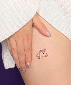 a woman's stomach with a unicorn tattoo on it