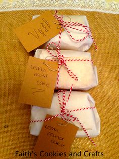 four cookies wrapped in white paper with red twine and tags attached to the top