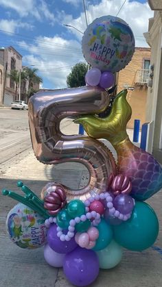 the number five balloon sculpture is made out of balloons and streamers, including mermaid tails