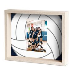 a group of young women standing next to each other in front of a volleyball ball