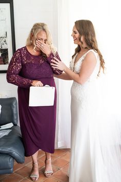 two women standing next to each other near a couch