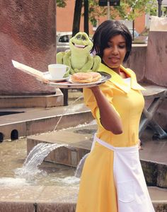 a woman holding a plate with food on it and a frog sitting on top of it