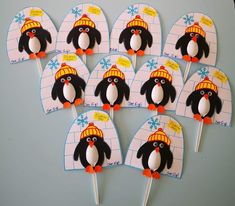 a bunch of penguin cupcake toppers with hats on them sitting on a table