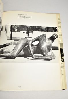 an open book with a black and white photo of a woman laying on the ground