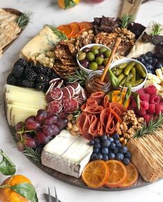 a platter filled with cheese, fruit and crackers